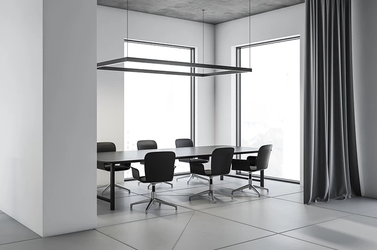 Biały pokój z czarnymi biurowymi krzesłami